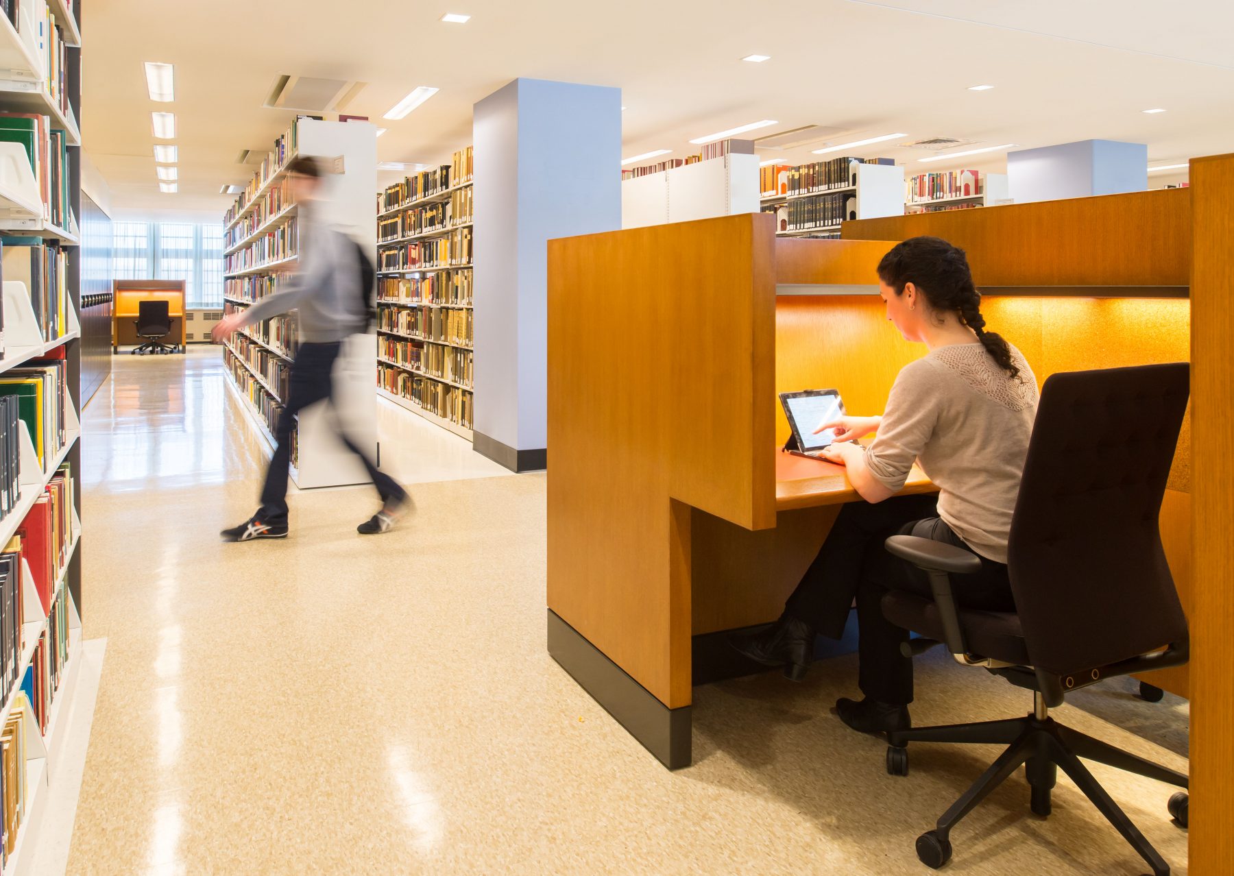 Princeton Firestone Library Desks with a student working and one walking by