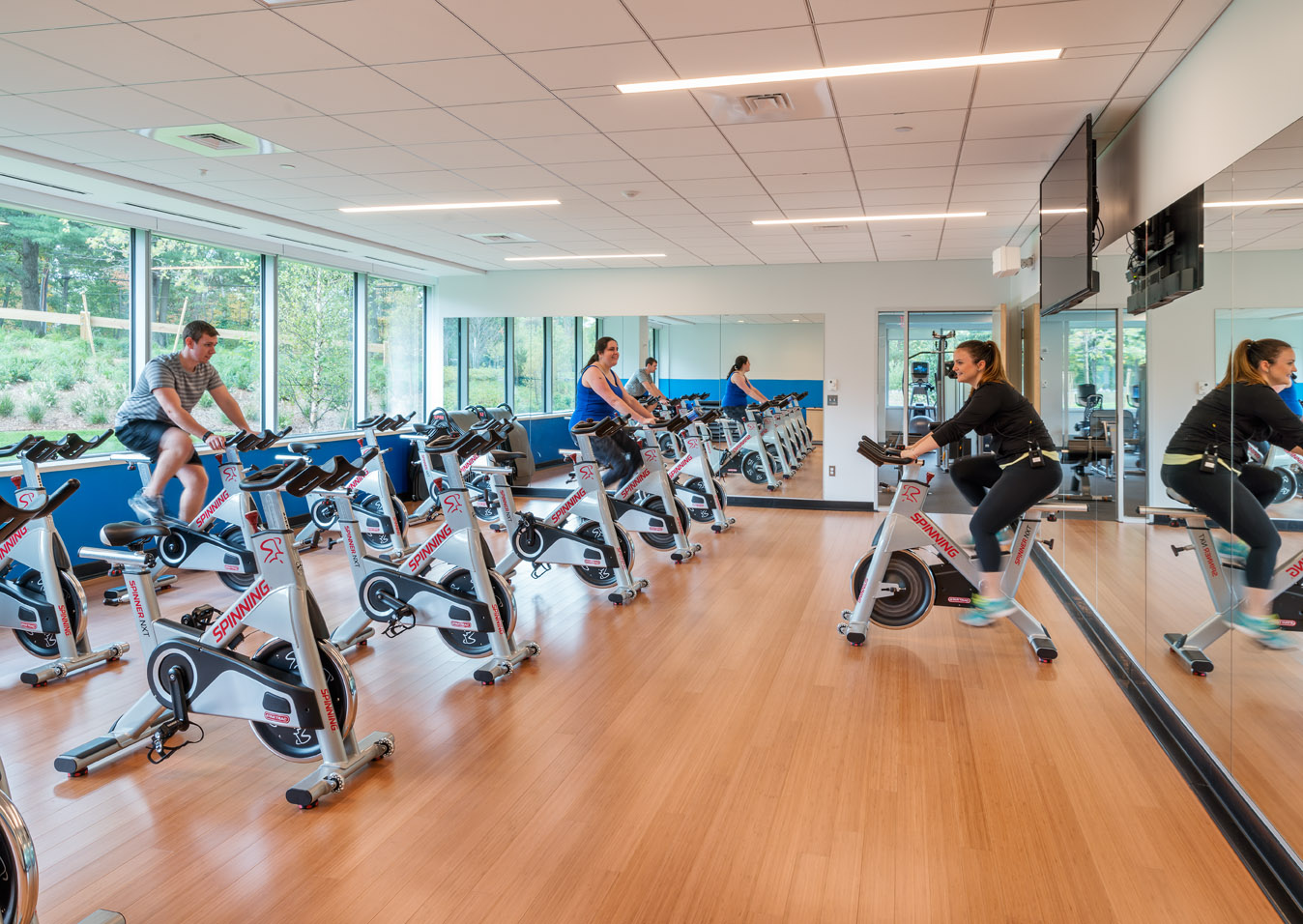 Vistaprint Cimpress Gym, an instructor gives bike lessons to two employees