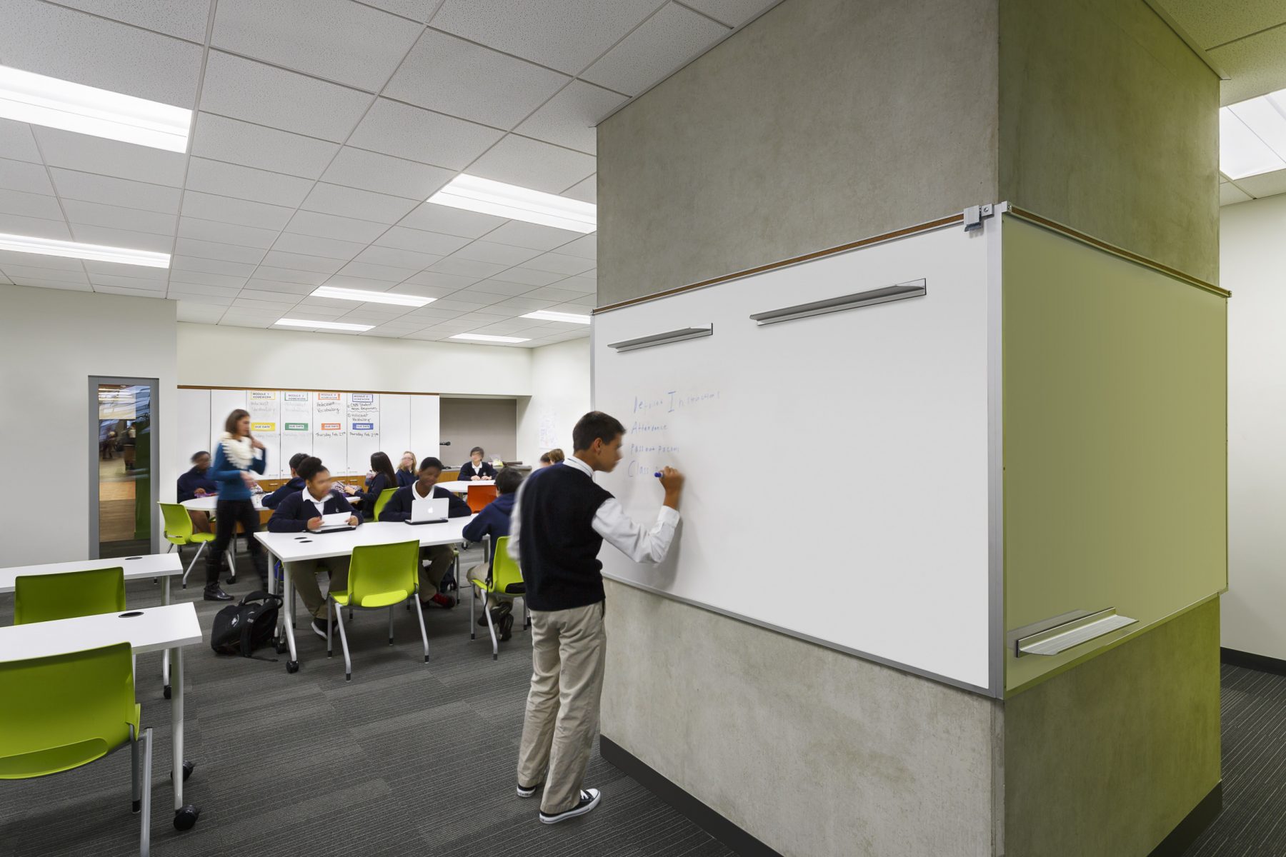 E3 Civic Hs Classroom, a student writes on the white board