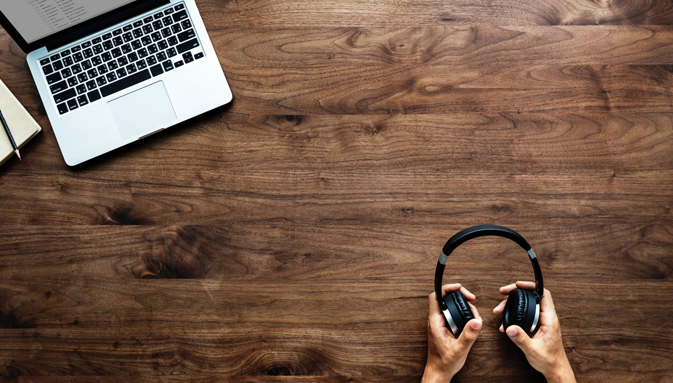 Laptop And Hands Holding Headphones