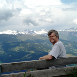 David Bowen sitting on a bench overlooking a mountain valley