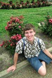 Josh Brophy sitting next to flowers