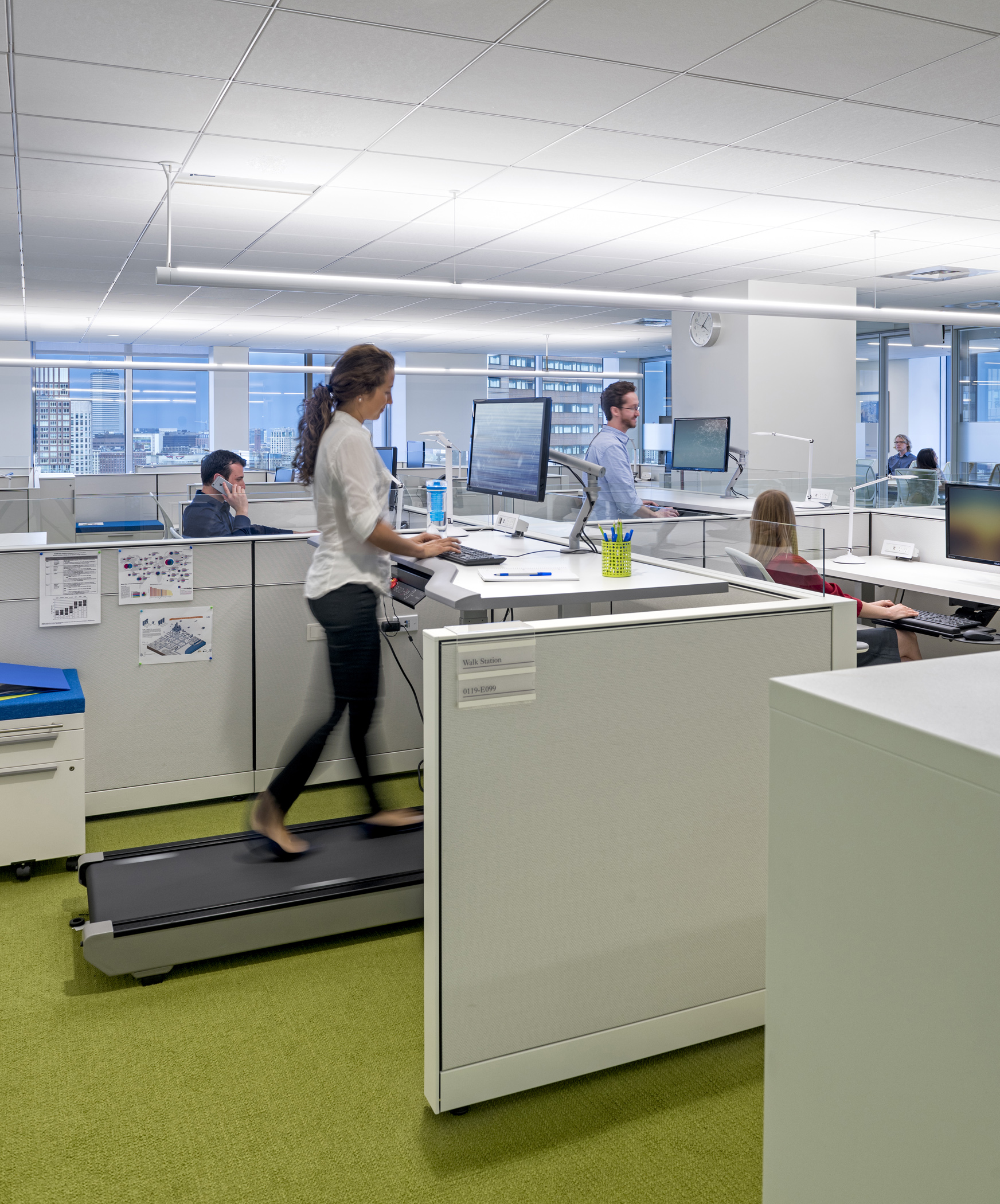 Blue Cross Blue Shield open office with a women walking on the treadmill as she works