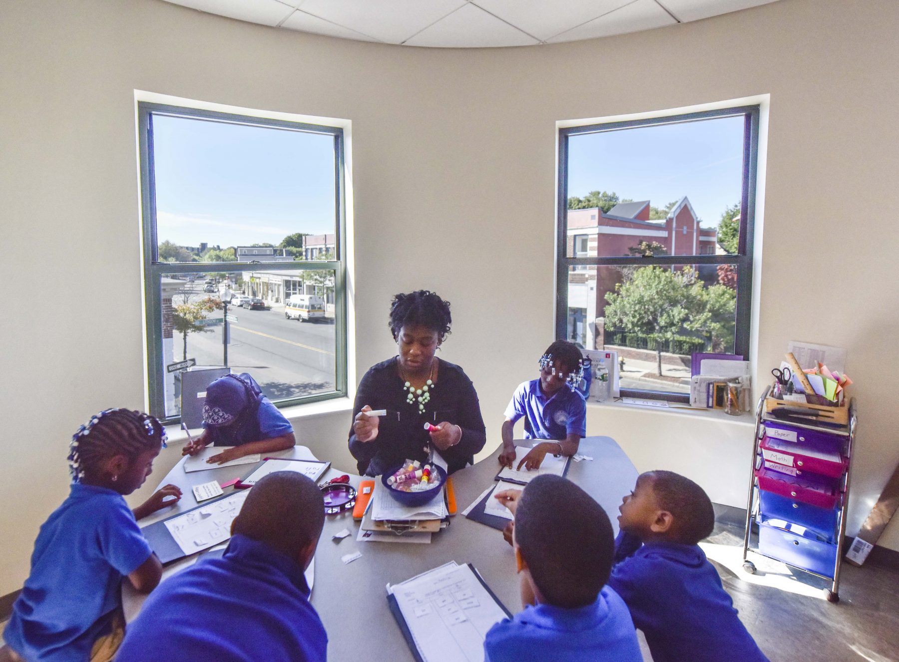 Codman Academy Classroom Dorchester, students gather around a table with a teacher