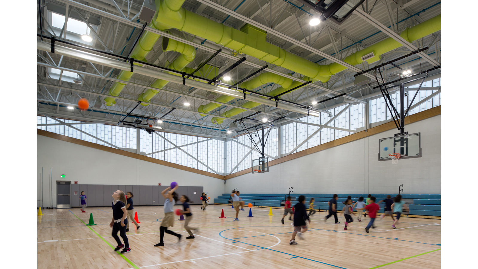 Irwin Jacobs Elementary School Gymnasium, students play basketball