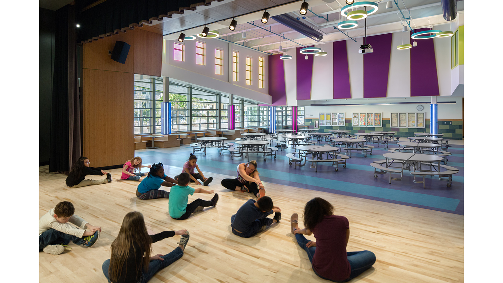 Irwin Jacobs Elementary School Interior, students stretch in the gym/cafeteria