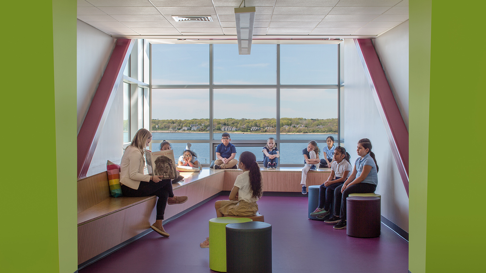 Irwin Jacobs Elementary School Interior, a teacher reads to a group of students on window seats