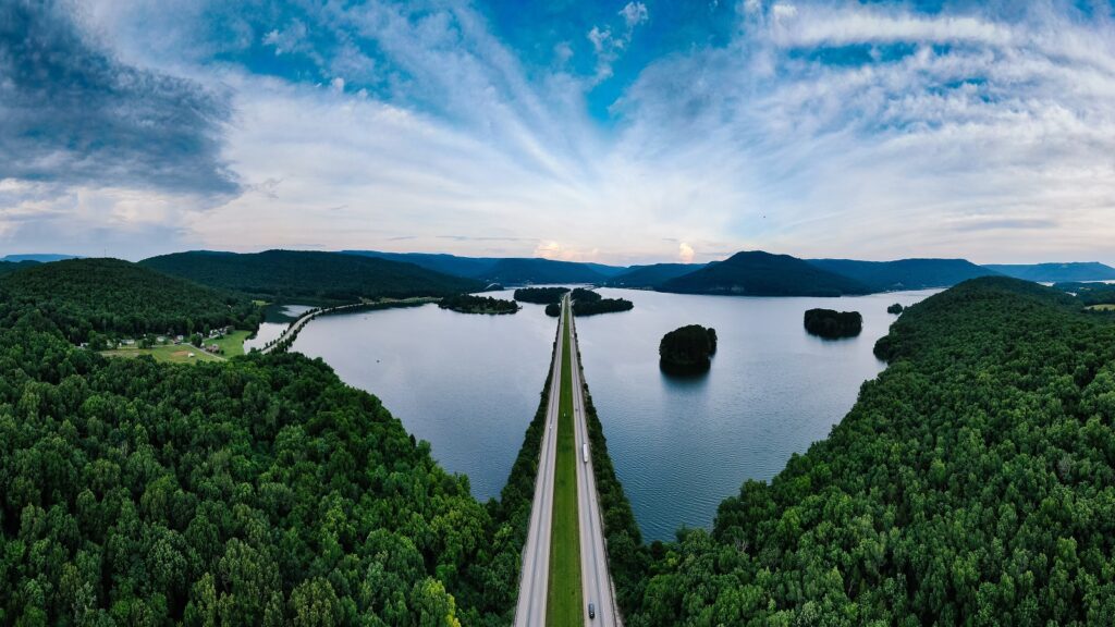 Acentech Forest Blog, a highway lined by trees and a lake