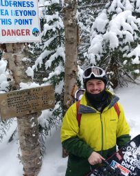A photo of Joe Barra with Snowboard standing in the snow in Chilcoot Pass