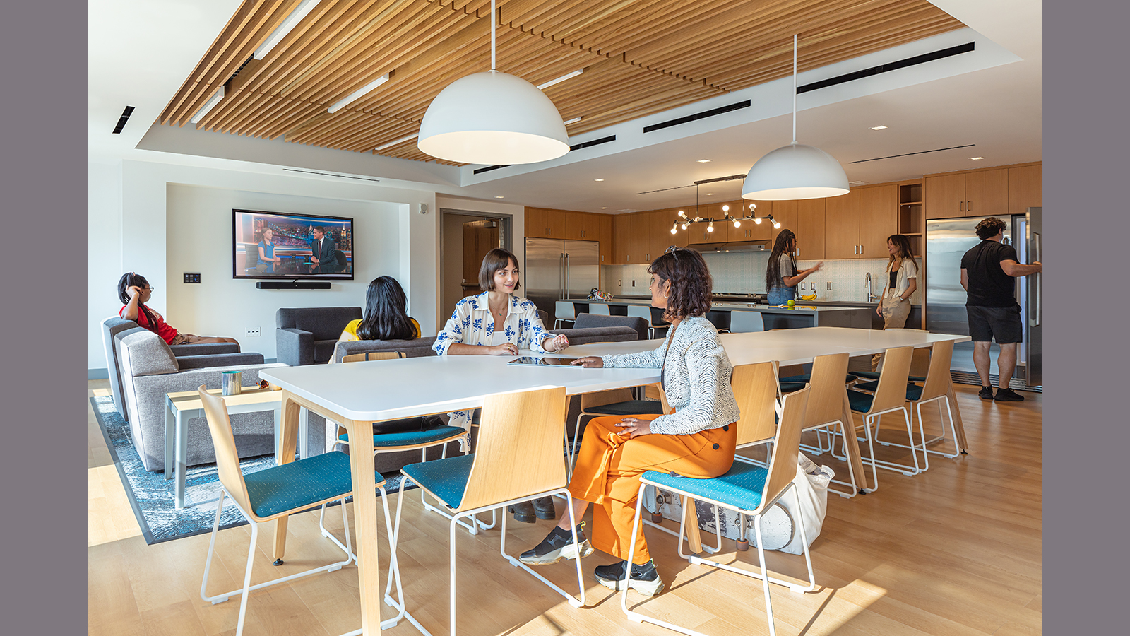 Loyola Marymount University Student Housing in Los Angeles, students sit in the kitchen/lounge
