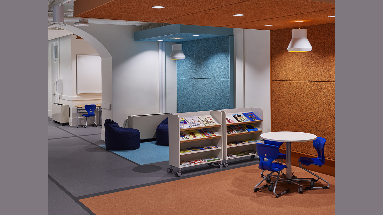 Creative Minds International Interior, two study stations next to rolling bookshelves